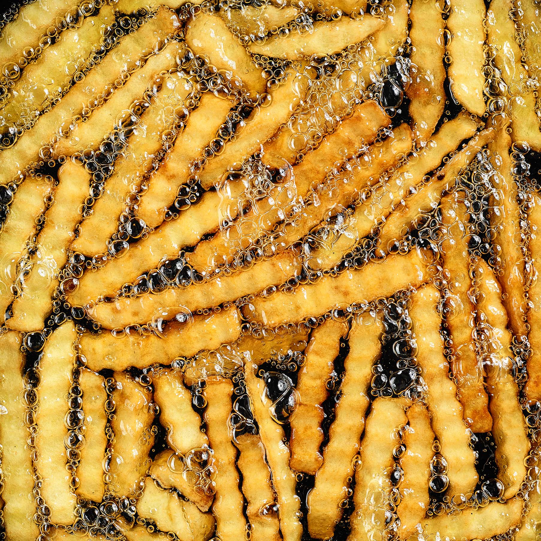 frying potatoes in pan with oil, top view